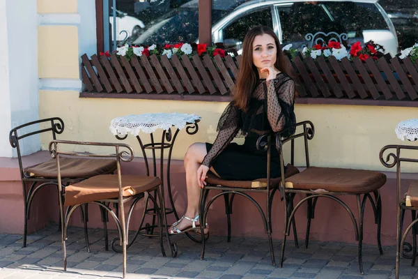 路上カフェで座っている美しい 魅力的な少女の肖像画 日を待っています ブルネット — ストック写真
