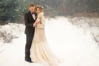 ormanda, mutlu bir çift, iki sevgili sarılma, özlem. gülümseme, Gelin ve damat. düğün kışın. takım elbise ve gelinlik. kar, sis olacak