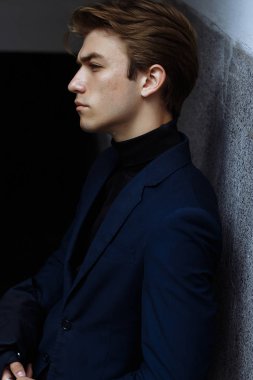 Şehrin üzerinde el, altın bilek watch.pensive gri background.watch üzerinde mavi elbiseli çekici bir genç adam profile.portrait adam