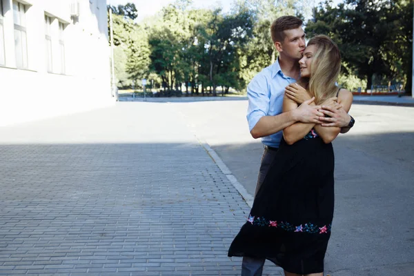 恋爱中的情侣们在城市里一栋建筑的背景下拥抱 面带微笑 吸引着 爱情人节 — 图库照片