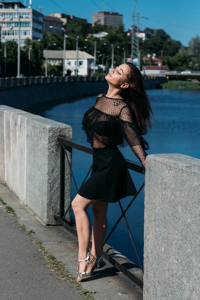 Beautiful Brunette Stands Bridge River City Girl Black Dress Puts — Stock Photo, Image