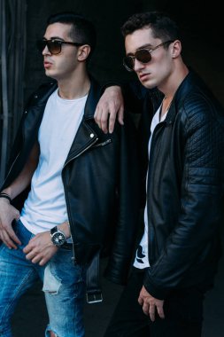 güzel ve çekici adam şehirde ayakta, poz. bir siyah deri ceket, beyaz T-shirt, kot pantolon ve beyaz ayakkabı giymiş. ayna Binası yakınında. siyah gözlük şehirde dolaşmak. iletişim. Toplantı arkadaşlar.