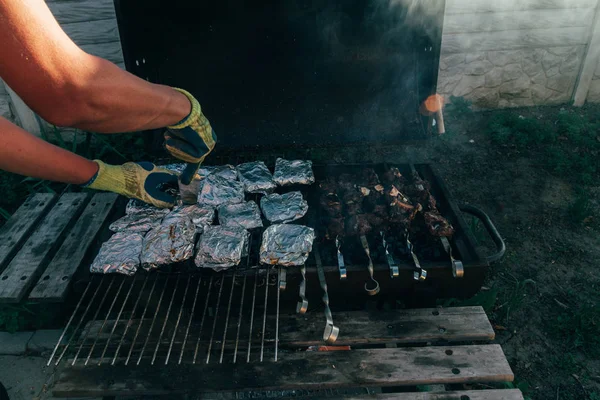 金属串上的烤小鱼烤肉串 用大量的烟雾煮烤肉烧烤 新鲜牛肉片 传统的东方菜木炭和火焰 街头食品 — 图库照片