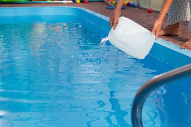 Erkekler eller hafif sıvı plastik bir tank bir havuza su içine dökün. kimyasal su arıtma, alkali dengesi, sağlıksız conditions.disinfection ve yüzme için hazırlık. Havuz Bakımı