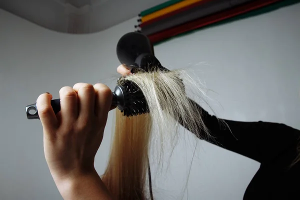 Retrato de una chica Peluquería seca el cabello con un secador de pelo en el salón de belleza — Foto de Stock