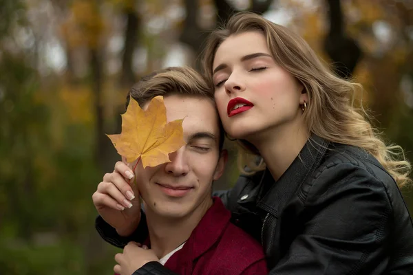 The couple hugs and sadly, the girl hugs the guy from behind and leans a yellow sheet to his face — Stock Photo, Image