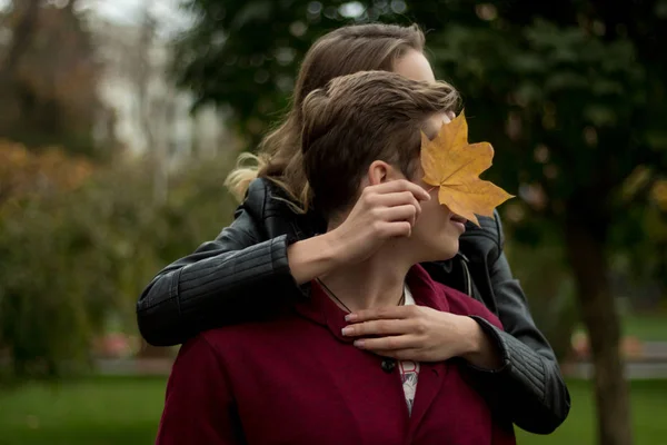 Het paar knuffels en helaas het meisje knuffels de man van achter en leunt een geel vel op zijn gezicht — Stockfoto
