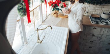 yanında belgili tanımlık pencere, beyaz bir gömlek mutfakta bir kupa tutan kız. sabah kahvesi, Kahvaltı, sonra seks sexy.holiday