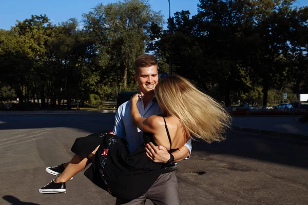 Casal feliz, homem e mulher, sorrindo. homem detém mulher e gira — Fotografia de Stock