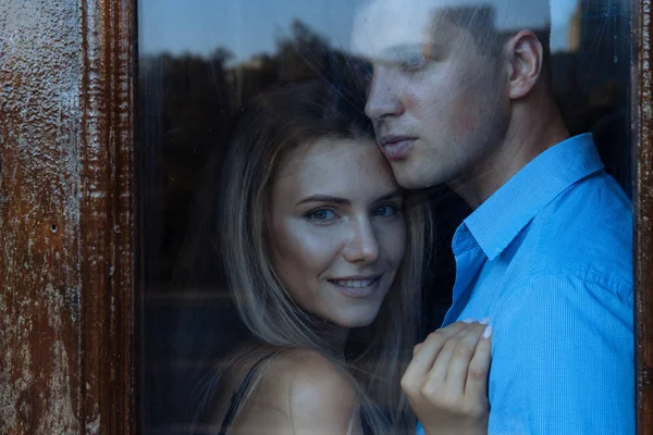 Couple amoureux, un homme étreint une fille derrière le verre . — Photo