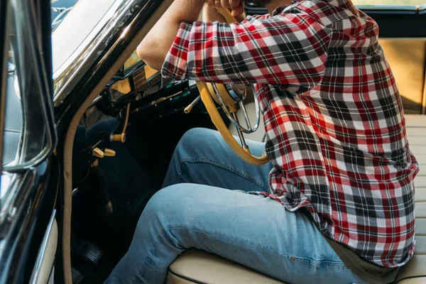 El hombre está sentado al volante, el conductor. vista desde la ventana trasera. Vista trasera del turista en coche. Conceptos de viajes y vacaciones de verano . — Foto de Stock