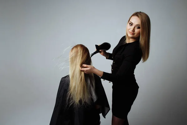 Retrato de una chica Peluquería seca el cabello con un secador de pelo en el salón de belleza —  Fotos de Stock