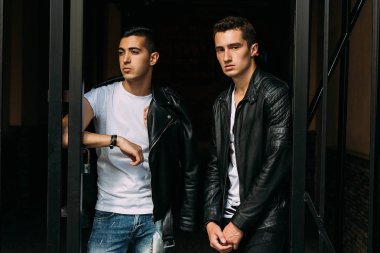 iki çekici erkek yakın, arkadaşlar, siyah ceket ve beyaz T-shirt poz ayakta