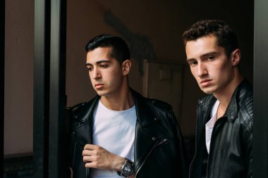 iki çekici erkek yakın, arkadaşlar, siyah ceket ve beyaz T-shirt poz ayakta