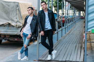 iki çekici erkek yakın, arkadaşlar, siyah ceket ve beyaz T-shirt poz ayakta