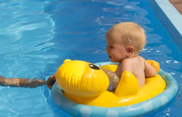 Kleines Mädchen schwimmt in Rettungskreis orange im Pool — Stockfoto
