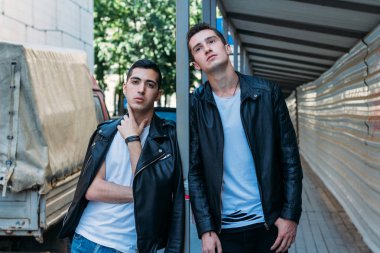 iki çekici erkek yakın, arkadaşlar, siyah ceket ve beyaz T-shirt poz ayakta