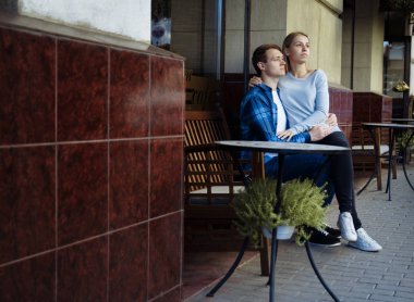 mutlu çift masada dışarıda oturuyor. bir adamın kollarında kız. Sokak Kafe