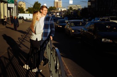 mutlu çift sokakta kucaklayan, yol yakınında. vagonun yanındaki çitin yanında durmak