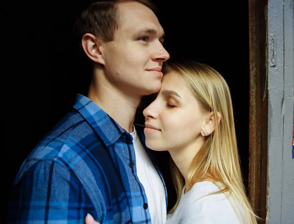 Glückliches Paar, das sich umarmt, Nahaufnahme, blond. auf schwarzem Hintergrund stehen und sich umarmen — Stockfoto