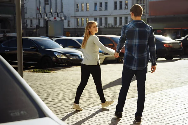 Щаслива пара тримає руки в місті, фліртує, йде по вулиці. туризму — стокове фото