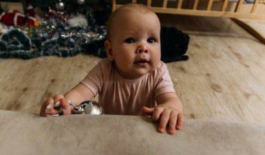 bebek kameraya gülümsüyor. yakın çekim portre. bir Noel ağacı oyuncak tutarak