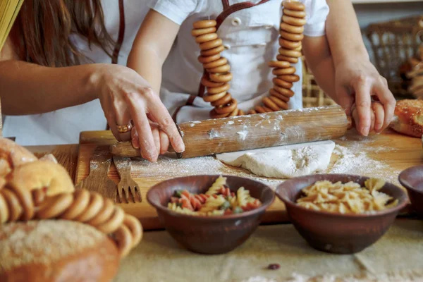 Ein Kind mit seiner Mutter in der Küche rollt einen Teig aus, Teigwaren, Mehl, eine Bäckerei, Brot. Meisterkurs — Stockfoto