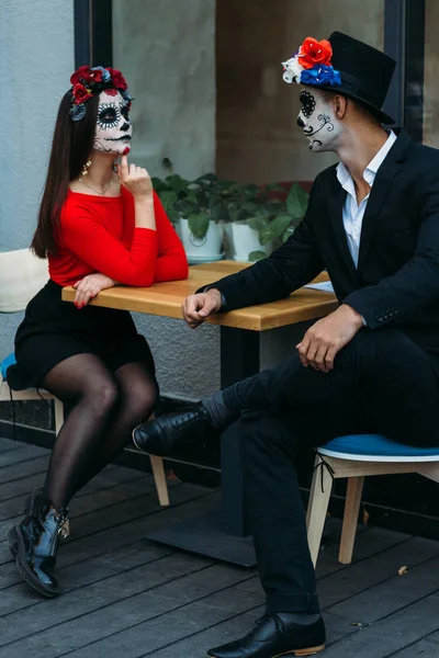 Una pareja, usando maquillaje de cráneo. Día de todas las almas. Maquillaje de cráneo de azúcar de niño y niña. Pintado para Halloween. muertos en la ciudad. zombie caminar . —  Fotos de Stock