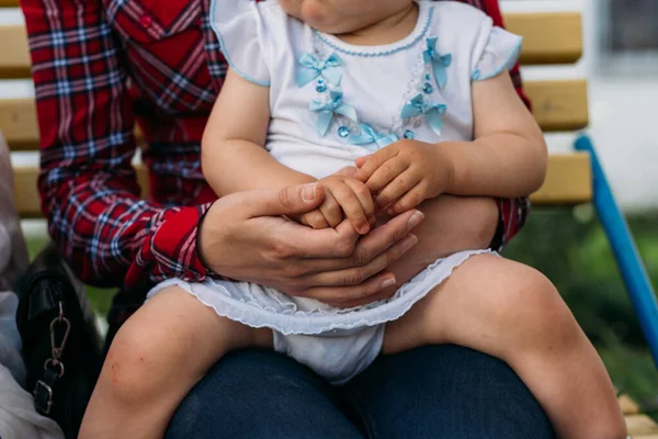 Gyermekek kezei egy felnőtt kezében.gyermekek kezei felnőtt kezekben.felnőtt karok ölelik a gyerekeket. Anya gyűrűbe fogja a baba kezét. — Stock Fotó