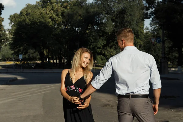 Casal feliz, homem e mulher, sorrindo. homem detém mulher e gira — Fotografia de Stock