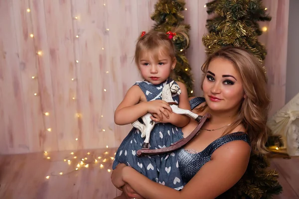 Smiling joyful mom with her daughter near the Christmas tree — Stock Photo, Image