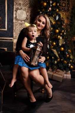 Gülümseyen anne kızıyla birlikte Noel ağacının yanında