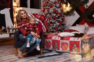 Gülümseyen anne kızıyla birlikte Noel ağacının yanında