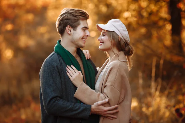 Happy, couple in love hugs and smiles on the street, autumn, green scarf and cap, man and woman on a date, valentines day. walk in the park — Stock Photo, Image