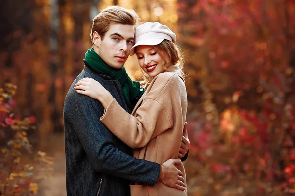 Happy, couple in love hugs and smiles on the street, autumn, green scarf and cap, man and woman on a date, valentines day. walk in the park — Stock Photo, Image