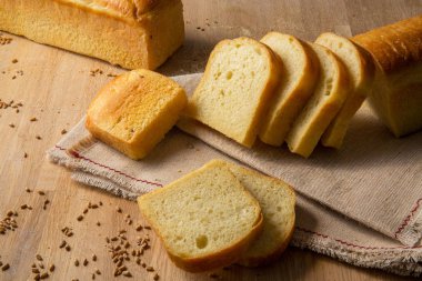 Buğday taneleri çul zemin üzerine beyaz ekmek dilimlenmiş