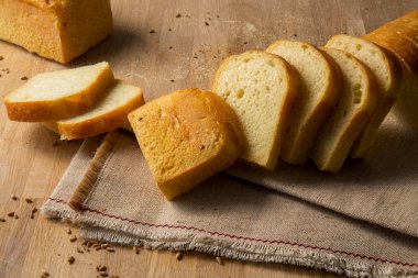 Buğday taneleri çul zemin üzerine beyaz ekmek dilimlenmiş