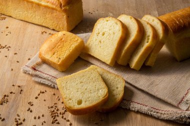 Buğday taneleri çul zemin üzerine beyaz ekmek dilimlenmiş