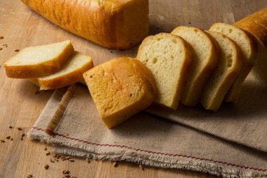 Buğday taneleri çul zemin üzerine beyaz ekmek dilimlenmiş