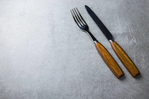 Çatal ve bıçakla gri bir arka plan üzerinde