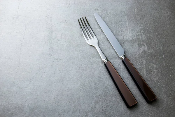 Çatal ve bıçakla gri bir arka plan üzerinde