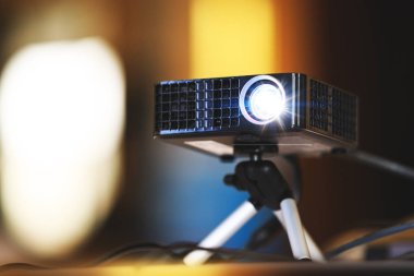 İş toplantısı veya oda ofis tanıtımı gerçek projektör. Projektörün sinema ve video projeksiyon için kapatın. Tripod Hall'un orada ya da Seminer Toplantı odasında siyah projektörde. İş ve eğitim kavramı.