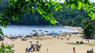 İnsanlar Gölü Sahilde güneşli bir gün tadını çıkarın. Gidiş için bir plaj, Lac-Simon yüzmeye bir tipik eğlence Quebec yaz saati, bir faaliyettir. 