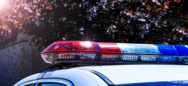 Police lights on car during traffic surveillance on the city road. Flash light on the vehicle of the Emergency Services. Red and blue flashes on the cars of the Patrol specialized unity. Best conceptual picture for media projects.