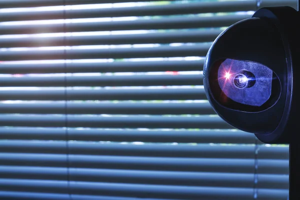 Güvenlik kamerası ofis binası veya pencere panjur önünde ev oda içine. Duvarda yüklü Cctv kamera veya gözetim sistemi. İzleme ekipmanları muhafızı tarafından özel mülkiyet koruması. 