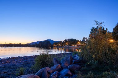 Magog, Quebec eyaleti, Kanada, Eylül 2018. Gece yansımaları Memphremagog Gölü'nün güzel Magog şehir. Dağlar, göl, gece gökyüzü ve korku veren su arka plan ile Kanada romantik manzara.