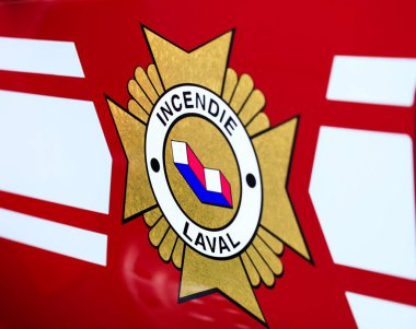 Laval, Canada: October 13, 2018: French inscription on the fire truck Incendie Laval. The logo of the Canadian Fire Department from Laval. Fire extinguishers emergency service in Quebec province. Firefighter unit in full mission activity.  clipart
