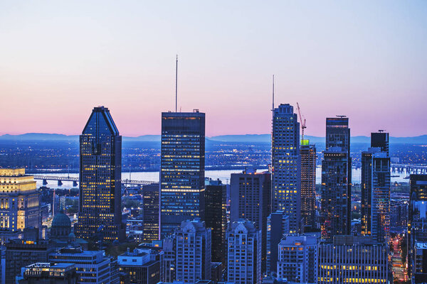 Beautiful red and blue sky and sunrise light over Montreal city in the morning time. Amazing view from Mont-Royal with modern architecture. Stunning panorama of Montreal downtown skyline and business buildings.