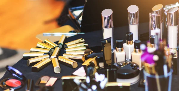 Collection de rouge à lèvres doré. Grand ensemble de produits cosmétiques se trouvent sur la table. Kit de maquillage réel d'esthéticienne professionnelle . — Photo
