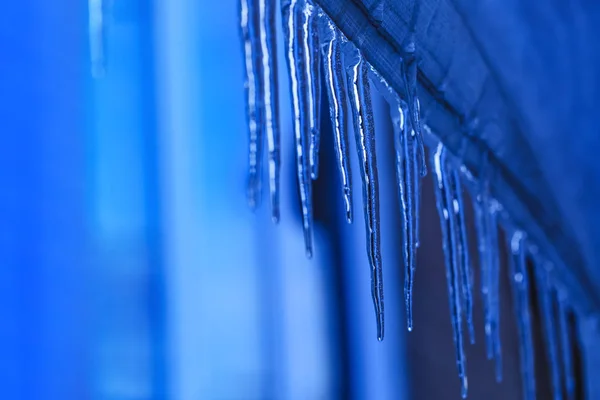 Κρεμασμένος παγοκρύσταλλος κατά τη διάρκεια της άνοιξης. Παγοπάγους με κρυστάλλινη υφή στο χειμερινό φόντο. Σταγόνες νερού που πέφτουν από σταλακτίτες την ημέρα της ηλιοφάνειας. — Φωτογραφία Αρχείου